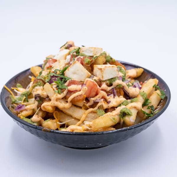 WOW TIKKA's Indian-style loaded fries with paneer, tomatoes, onions, green chutney, and sauce.