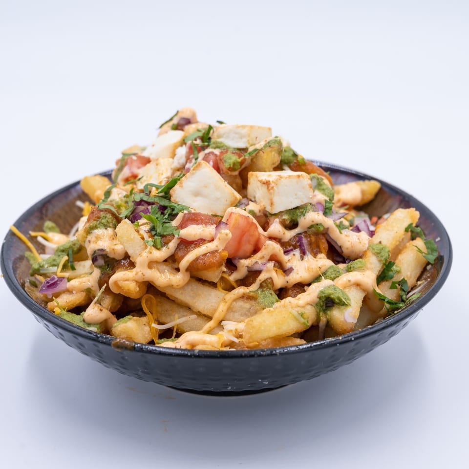 WOW TIKKA's Indian-style loaded fries with paneer, tomatoes, onions, green chutney, and sauce.