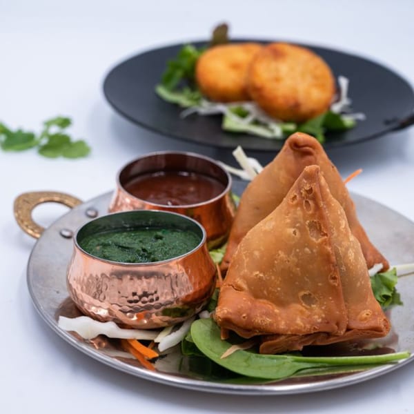 WOW TIKKA's golden-fried samosas and potato patties with green and brown chutneys.